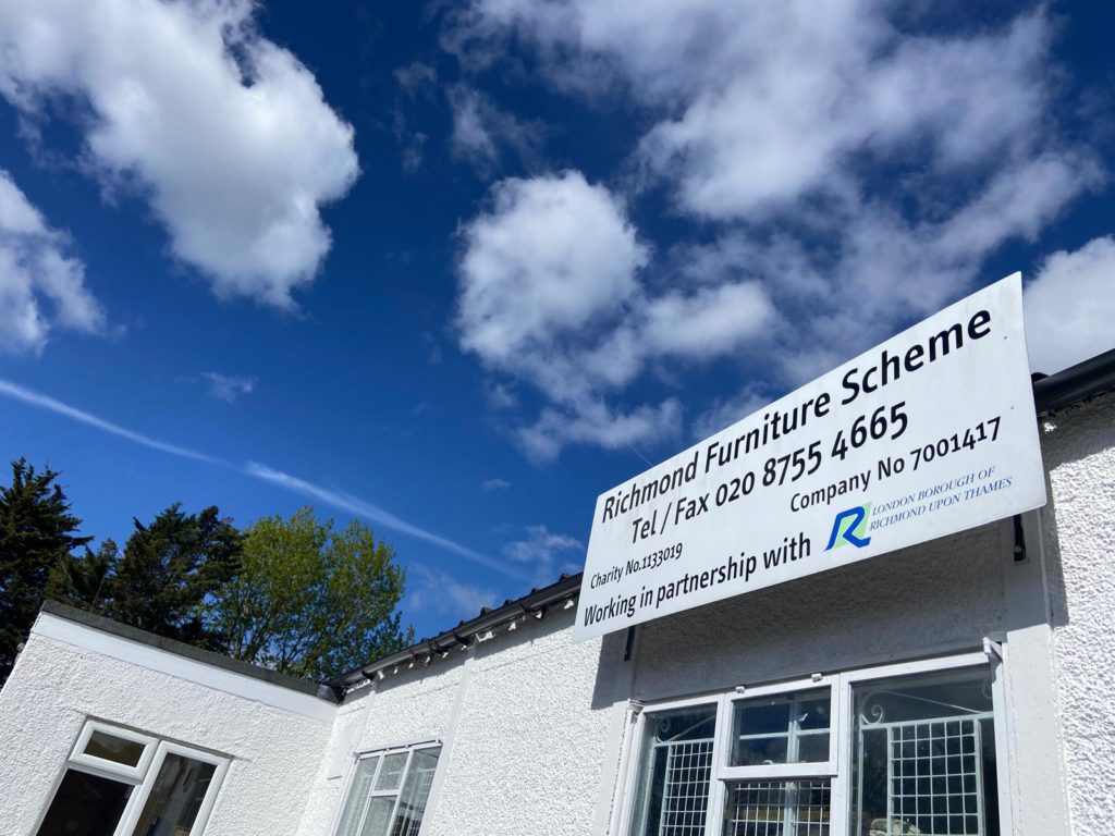 Richmond Furniture Scheme site office with a signboard displaying the charity number, company number and partnership with London Borough Richmond upon Thames